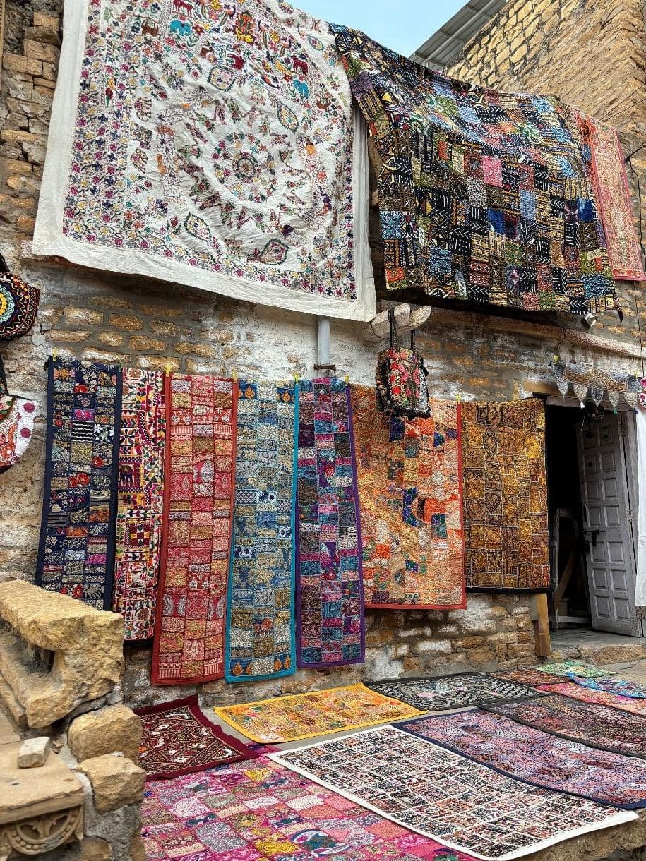 Assorted decorated rugs on display outside